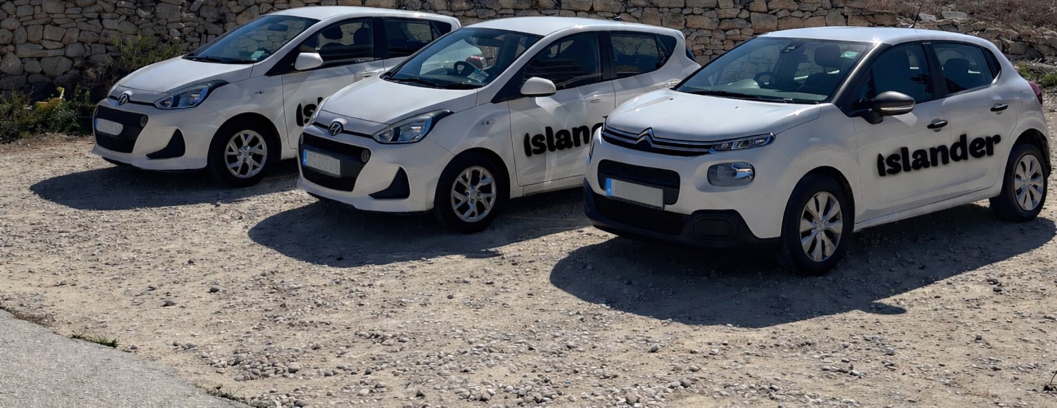 Islander hire cars parked beside a Maltese rubble wall in Bugibba